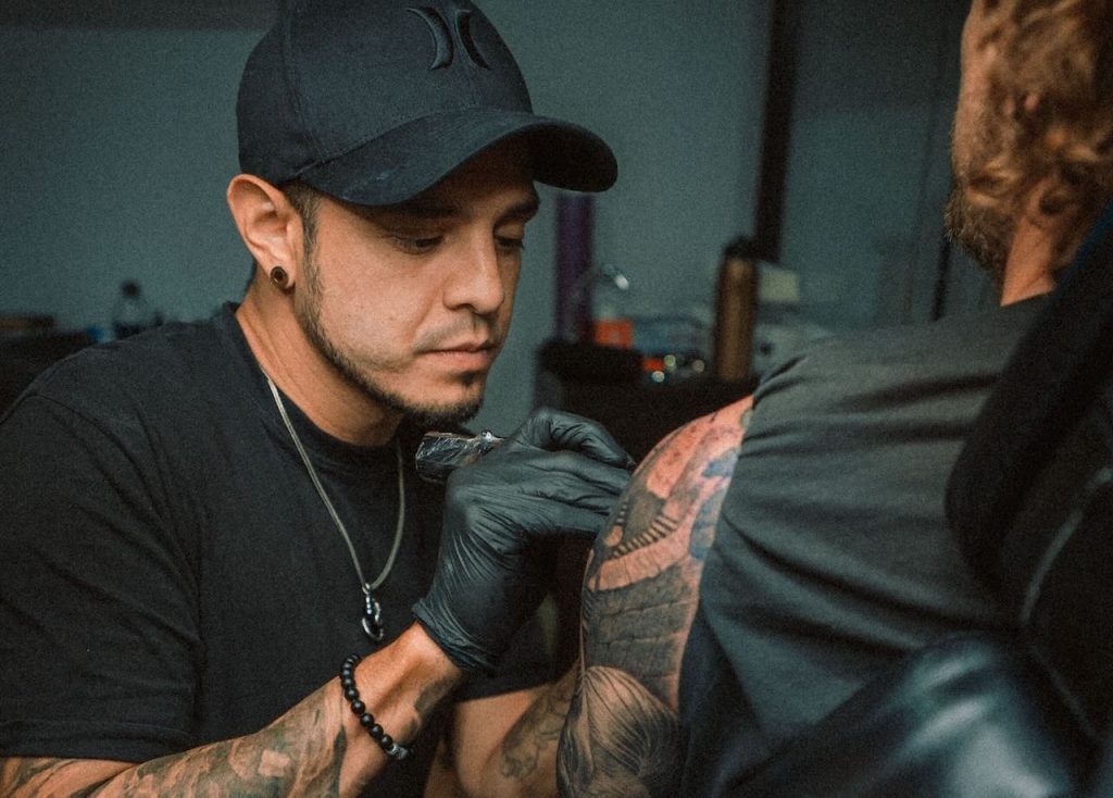 Juanjo Art, realistic tattoo artist in Madrid, working on a custom black and grey piece.